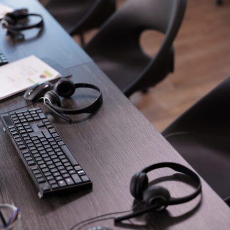 empty-helpdesk-office-with-telephony-equipment-reception-give-assistance-no-people-telemarketing-space-customer-service-client-support-remote-helpline-headphones-min